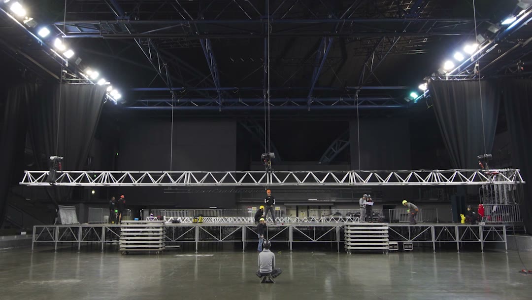 Montage de gril scénique en salle, structure suspendue au-dessus du plateau